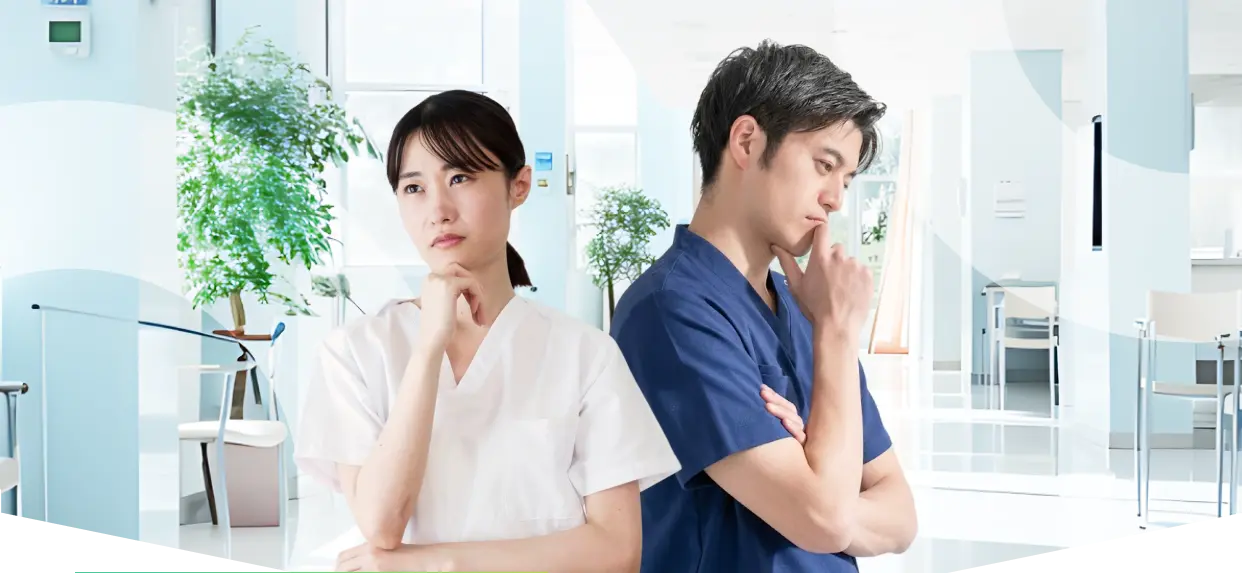 医療従事者の男女が考え込んでいる写真